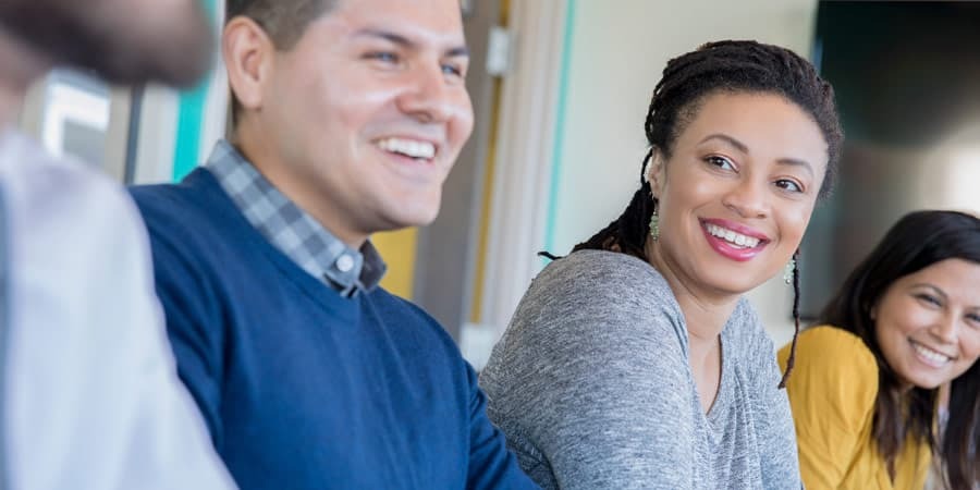 3. A team of professionals gathered in a meeting room, focused on a presentation and exchanging ideas