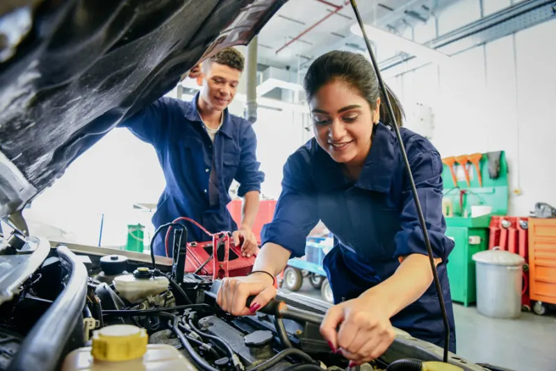A group of career technical education students working on a vehicle